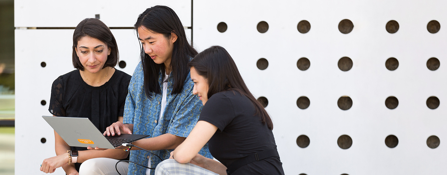 Assistant Professor Delaram Yazdansepas and students looking at laptop